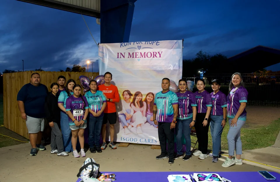 Run for Hope participants gathered beside the remembrance banner honoring loved ones